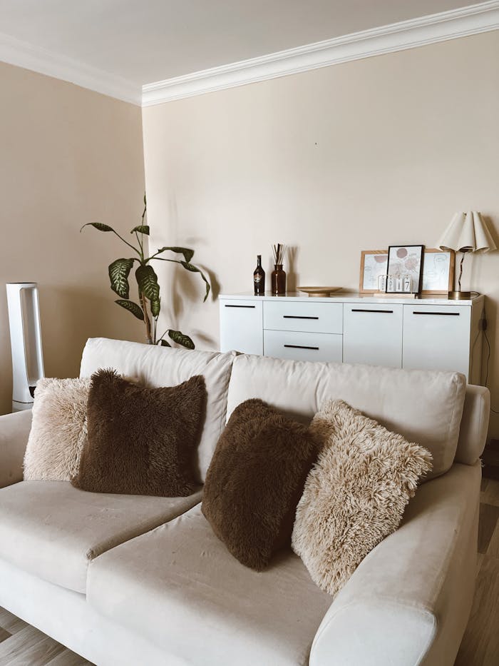 gallery-3 A stylish and cozy living room featuring a white sofa with fluffy cushions and modern decor.