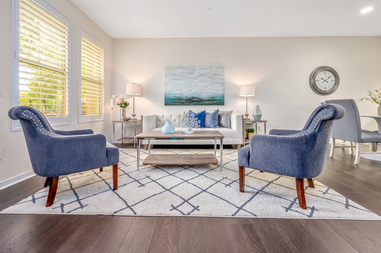 services-03 Spacious living room with stylish blue chairs and decor.