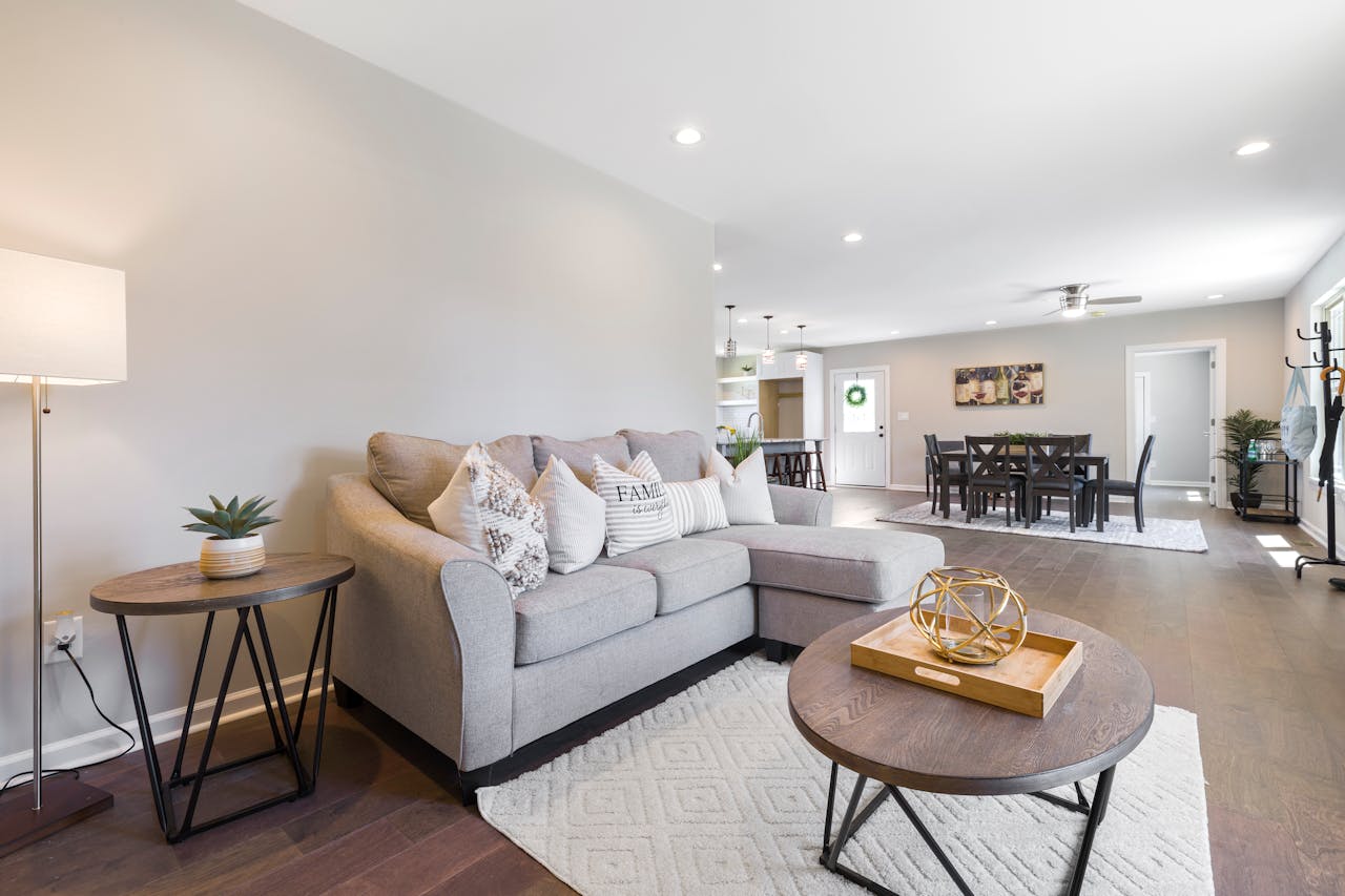 about-01 Spacious modern living room featuring stylish furniture and neutral decor.